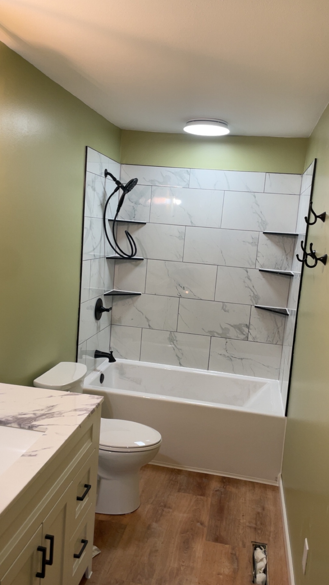 Full bathroom remodel with marble subway tile, black fixtures and quartz vanity